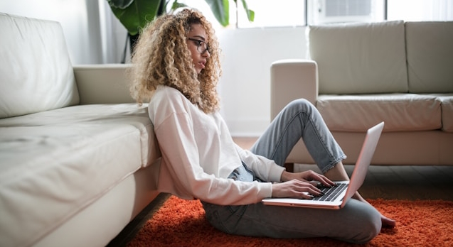 Woman sitting on the floor and working on a laptop